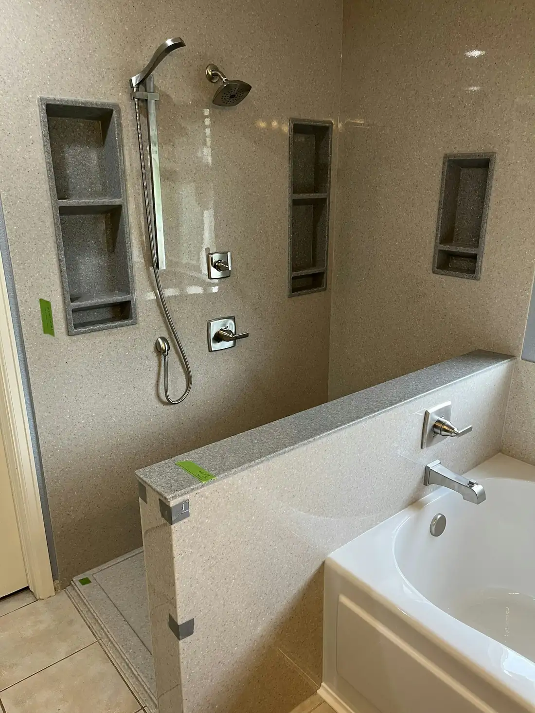 Douche aux murs beiges avec niches encastrées, baignoire à côté