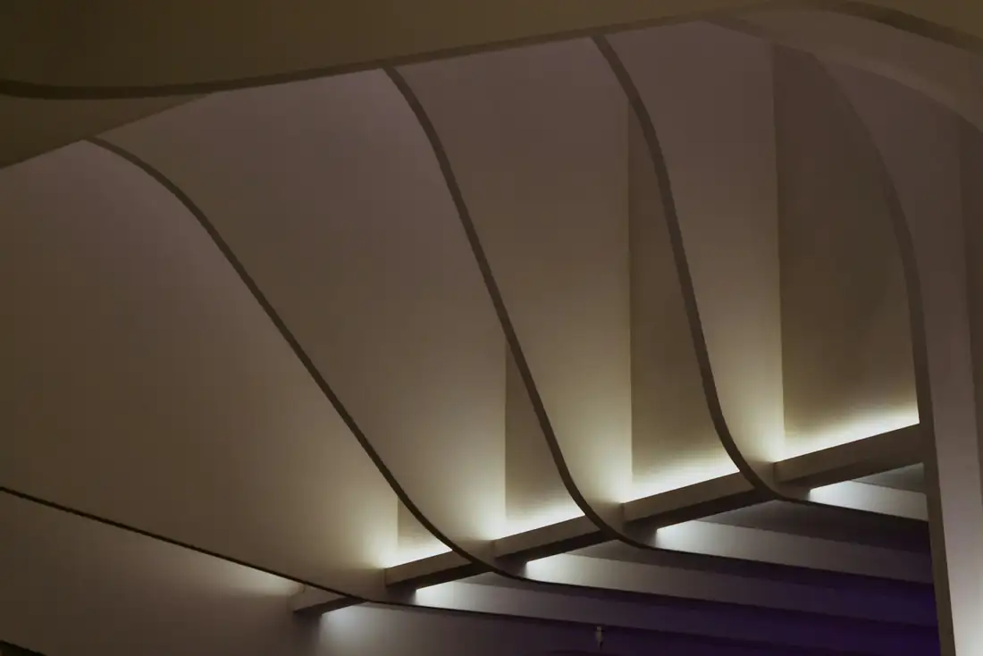 Plafond aux panneaux courbes éclairés par en dessous