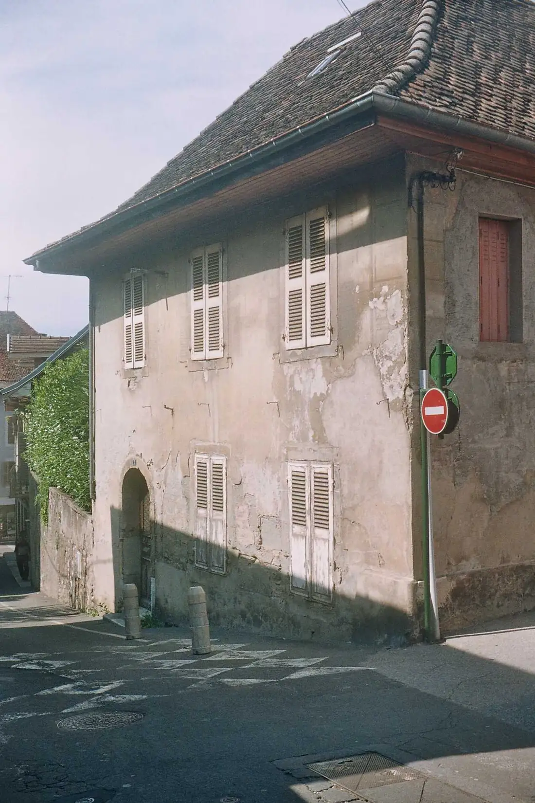 Vieille maison de Rumilly à l’enduit pâli, toit de tuiles en écailles